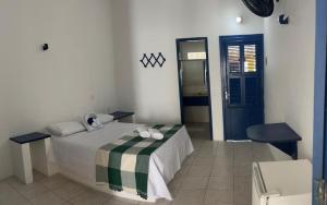 um quarto com uma cama e uma porta azul em Pousada Palamós Uruaú em Beberibe
