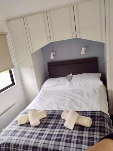 1 dormitorio con 1 cama con 2 toallas en Bunnahabhain 5 - Farm Stay - Stunning sea and rural views en Stranraer