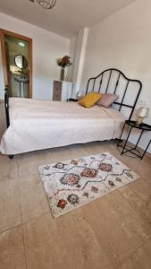 a bedroom with a large bed with a rug at Le Casa del Sol de Marta in Manilva