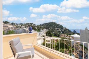 a balcony with a chair and a view of the city at Casa Levante Luxury Apartments Capri in Capri