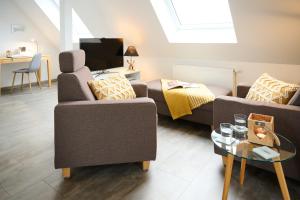 a living room with two couches and a tv at Haus Burgsponheim in Burgsponheim