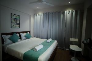 Un dormitorio con una cama grande con almohadas verdes y blancas en SUNBRIGHT ROOMS & RESIDENCY en Thane