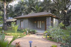 a small brick house in a garden at Tattvamasi Retreat in Mumbai