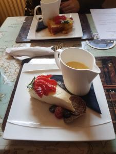 a plate of food with a cup of tea and fruit at Cross Keys Hotel Chatteris in Chatteris