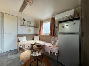 a small room with a couch and a refrigerator at Mobil home 4-6 personnes sur emplacement XL in Gassin