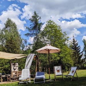 a group of chairs and an umbrella and a table at GA Grudzianka in Lwówek