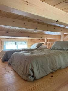 um quarto com 2 camas num chalé de madeira em The Bellefonte Campground em Bellefonte