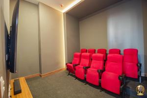 een conferentieruimte met rode stoelen en een scherm bij Hermoso Apartamento tipo Loft en Rodadero Santa Marta in Santa Marta