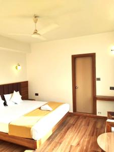 a bedroom with a large bed and a wooden floor at The Bassu's Gangtok in Gangtok