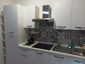 a kitchen with white cabinets and a black and white tiles at La casa di Andrea in Cogliate +24 photos