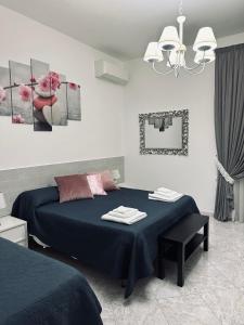 ein Schlafzimmer mit einem blauen Bett und einem Kronleuchter in der Unterkunft B&B Villa D'Errico in Casapulla