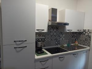 a kitchen with a white refrigerator and a sink at La casa di Andrea in Cogliate