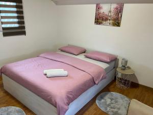 a bedroom with a bed with two towels on it at Apartment Helena Airport in Podgorica