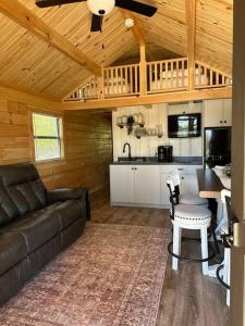 a living room with a couch and a table and a kitchen at The Bellefonte Campground in Bellefonte
