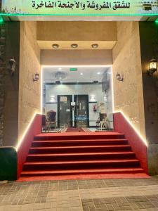 a staircase in a building with a red carpet at Najmat Alnoor Almaabdah Hotel in Makkah