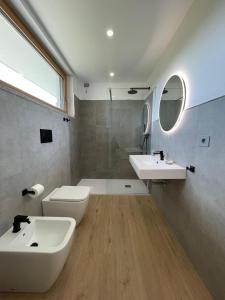 y baño con 2 lavabos, aseo y espejo. en Casa Vacanza Acquamarina en Porto Torres