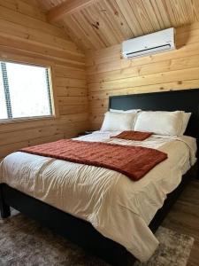 a bedroom with a bed in a wooden cabin at The Bellefonte Campground in Bellefonte