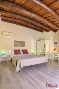 sypialnia z dużym łóżkiem i drewnianym sufitem w obiekcie B&B Cubbaita w mieście Palermo