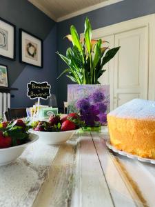 a table with a cake and a bowl of fruit at Bed and Breakfast da Peppino in Bianchi