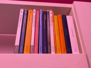 a row of books sitting on a shelf at Casa d amare in Gioiosa Marea