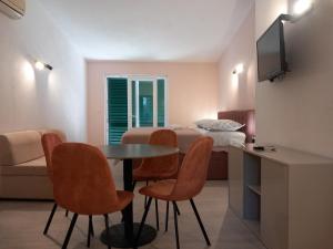 a room with a table and chairs and a bed at Mitan apartman in Tučepi