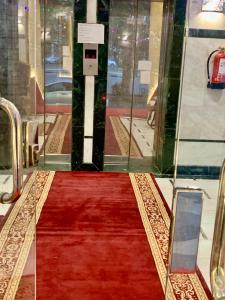 a red carpet in front of a glass door at Najmat Alnoor Almaabdah Hotel in Makkah