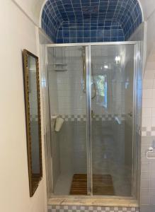 a shower with a glass door in a bathroom at Casa Reverie - Amalfi Coast in Praiano