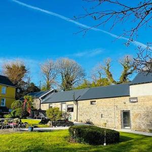 a large brick building with a grass yard at Sarahs Cottage at Pheasant Lane in Ráistín