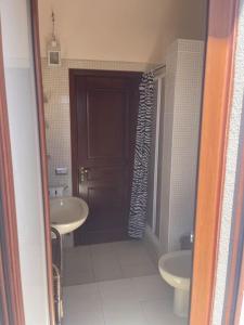 ein Badezimmer mit zwei Waschbecken, einem WC und einer Tür in der Unterkunft Nice Apartment in Margine Rosso in Quartu SantʼElena