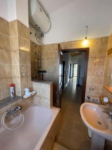 uma grande casa de banho com banheira e lavatório em Nice Apartment in Margine Rosso em Quartu SantʼElena