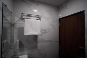 uma casa de banho com uma toalha pendurada numa parede em SUNBRIGHT ROOMS & RESIDENCY em Thane