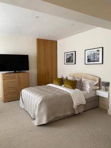 a bedroom with a large bed and a flat screen tv at Belgravia Apartments in London