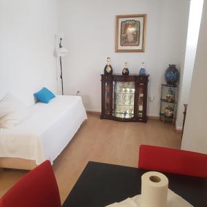 um quarto com uma cama branca e uma cadeira vermelha em José Domingos em Belmonte