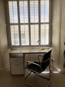 a desk with a chair in front of a window at Belgravia Apartments in London +90 photos