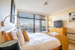 a bedroom with a large bed and a tv at Over the River - Emperors Wharf in York