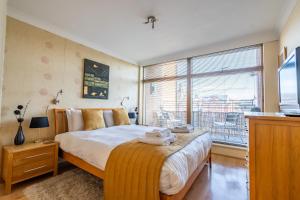 a bedroom with a bed and a large window at Over the River - Emperors Wharf in York
