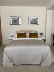 a bedroom with a large white bed with gold pillows at Belgravia Apartments in London