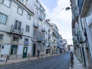 zwei Personen, die Fahrrad mit Gebäuden fahren in der Unterkunft Akicity Santos Astoria in Lissabon