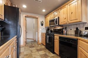 a kitchen with wooden cabinets and black appliances at Foxpoint 1678C by Moose Management in Park City