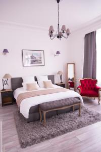 ein Schlafzimmer mit einem großen Bett und einem roten Stuhl in der Unterkunft Chic Appart - Sauna privatif in Tourcoing