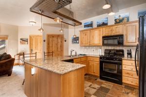 a kitchen with wooden cabinets and a stove top oven at Foxpoint 1684-H3 by Moose Management in Park City