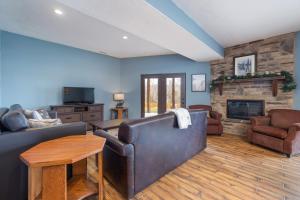 a living room with leather furniture and a fireplace at Lodge 17 in Branson