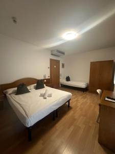 - une chambre avec un grand lit blanc dans l'établissement Athos Hotel, à Riva del Garda
