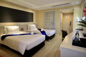 Habitación de hotel con 2 camas y escritorio en โรงแรมวีวิช V Wish Hotel, en Khon Kaen