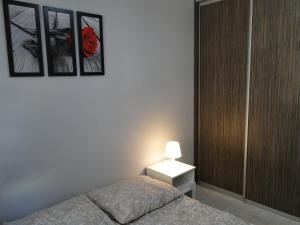 コウォブジェクにあるApartament Scandynawskiのベッドルーム1室(ベッド1台付)が備わります。壁に2枚の写真が飾られています。