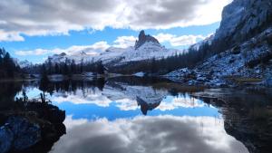 un reflejo de montaña en un lago en las montañas en Daniela Apartment en Cortina dʼAmpezzo