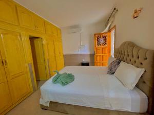 a bedroom with a large white bed with yellow cabinets at Villa Paradis in Marrakesh +128 photos