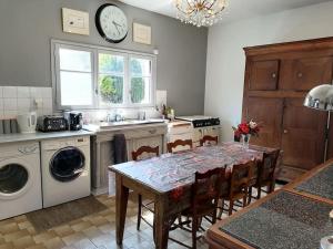a kitchen with a table with chairs and a clock on the wall at Brittany France 2 Beds Free Wi-Fi - Parking & Garden in La Haye