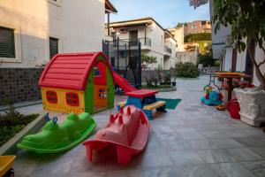 um parque infantil com uma casa de brinquedos e um escorrega em Harrys bar & apartments em Acharavi