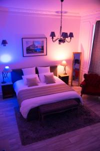 Chic Appart - Sauna privatif في توركوان: غرفة نوم بسرير كبير مع اضاءة ارجوانية